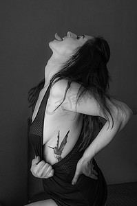 colibri摄影照片_带有蜂鸟 (colibri) 纹身的吐舌肖像的女人