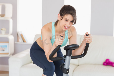 健康的黑发女郎在健身车上锻炼