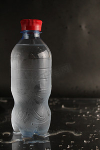 黑色背景上瓶子里的冷水。