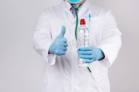 一件白色外套和蓝色乳汁手套的医生拿着透明