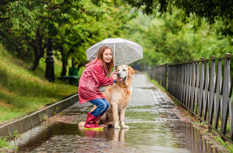 与狗共用雨伞的小女孩