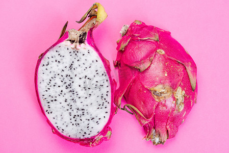 Pitahaya 或火龙果在粉红色柔和的背景下切成两半。