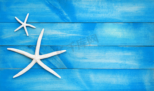蓝色木制背景上的两个海星。