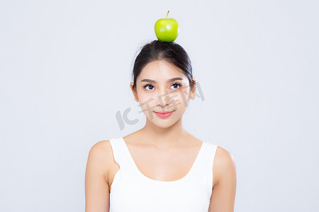 美丽的亚洲女人肖像微笑着，上面挂着青苹果果