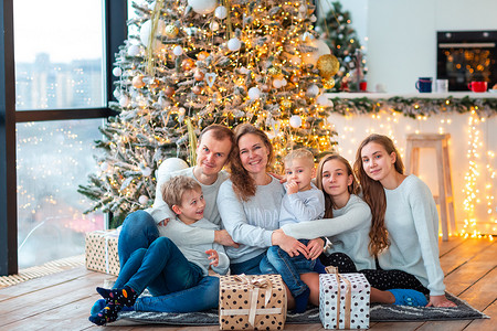 圣诞树附近幸福的家庭，带着礼物盒