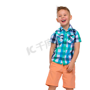 帅哥摄影照片_一个穿着衬衫和短裤的可爱小男孩。