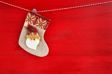 红色圣诞节背景。与圣诞老人的圣诞节袜子在红色木背景。