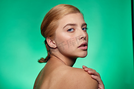 护肤品绿色背景摄影照片_皮肤清洁面部手术美容裸肩绿色背景的女性