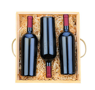 红酒拉菲摄影照片_木箱中的三个红酒瓶