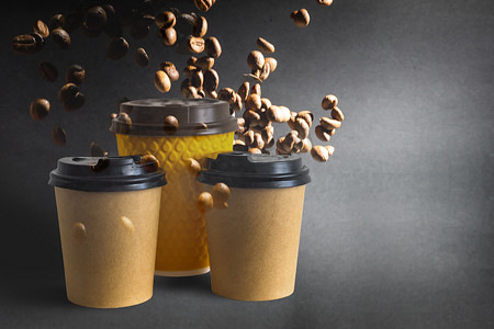 纸杯包装设计摄影照片_咖啡纸杯，深色背景上有咖啡豆。