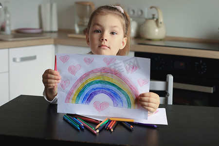 女孩在家画彩虹，这是英国国民医疗服务体系 (NHS) 的象征。