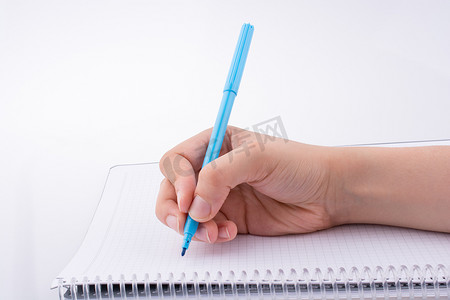 写字的手摄影照片_在笔记本上写字的手