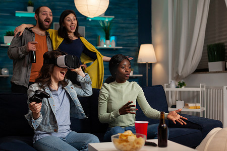 兴奋的快乐女人戴着虚拟现实耳机赢得游戏比赛
