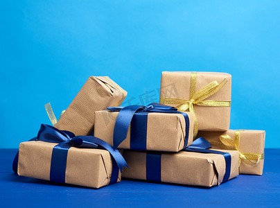 一堆礼物装在用棕色牛皮纸包裹的盒子里，并绑在无线网络上