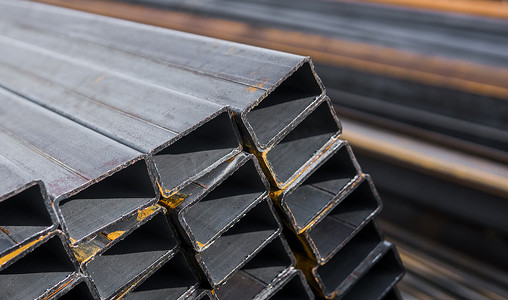 包角摄影照片_金属产品仓库中包装的方形扁轧管金属型材。
