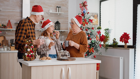 幸福的家庭戴着圣诞帽庆祝圣诞节假期吃烤巧克力饼干
