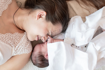 母性、婴儿期、童年、家庭、护理、医学、睡眠、健康、产妇概念 — 妈妈与新生婴儿的肖像，白色背景裹着尿布，文字位置，特写，软焦点