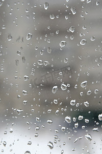 阴天下雨雨滴摄影照片_雨滴落在窗户上
