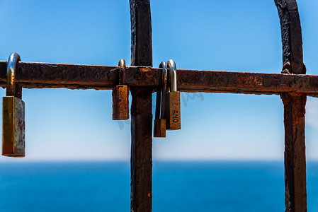 海边栏杆上挂着生锈的挂锁，这是表达爱意的传统方式