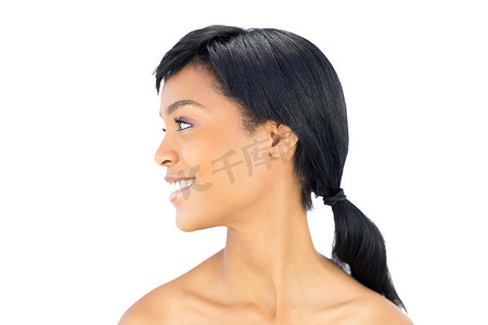 一个快乐的黑发女人的侧面图，她摆出一副远眺的姿势