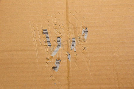 纸盒纹理摄影照片_撕裂的棕色纸板抽象背景，用于设计艺术作品的回收纸盒纹理。