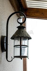 一盏黑色的灯从外面贴在房子的墙上。