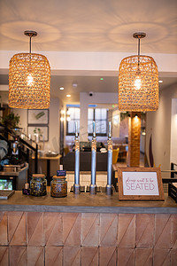 纯手工制作摄影照片_一家素食餐厅的木制柜台，上面挂着两盏手工制作的灯