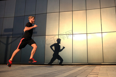 运动的年轻人在日落或日出时在户外跑步以保持健康。