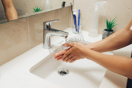 肥皂水洗手摄影照片_用肥皂人洗手，预防冬季流感病毒，保持卫生，阻止细菌传播。