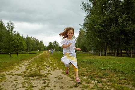 在公路上奔跑摄影照片_在大自然乡村小路上奔跑的女孩