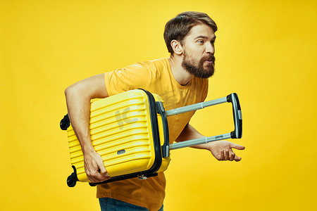 安踏喷绘摄影照片_一个带着黄色手提箱的男人俯身踏上旅程