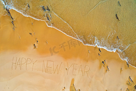 从海浪中拍摄的空中顶部和手写的新年快乐