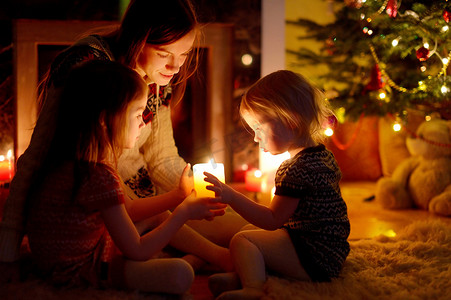 客厅内饰摄影照片_圣诞节在壁炉旁的幸福家庭