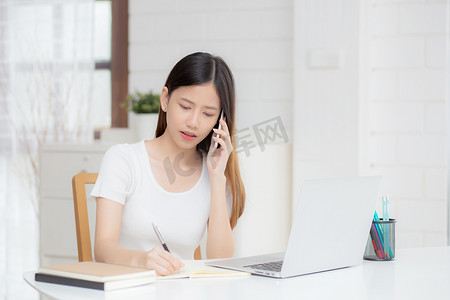 年轻的亚洲女性在笔记本电脑和智能手机上工作，在家里有压力和不安，女孩有问题和担忧，沮丧和不开心，商业和沟通概念。