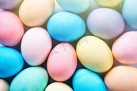 彩色复活节彩蛋被彩色水染色，淡蓝色背景上有美丽的图案，假日活动的设计理念，顶视图，全框。