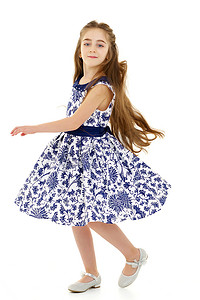 一个穿着裙子的小女孩正在旋转。