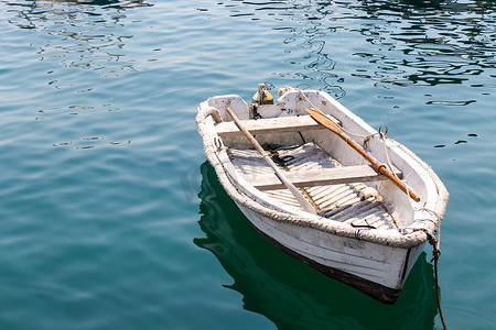 木船河上摄影照片_湖中蓝色平静水面上的白色木船