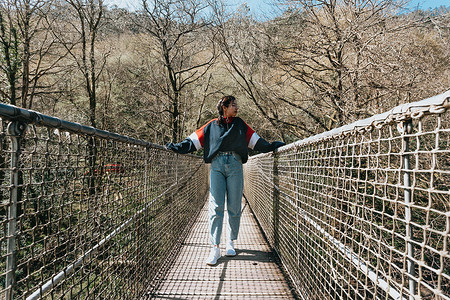 一位年轻女子在河上的一座桥上自由概念，有复制空间