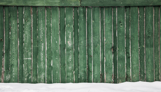 雪下的旧绿色栅栏