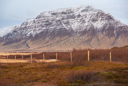 地质纹理摄影照片_紫色雪山展示地质纹理和层次冰岛景观与栅栏线红桃地形