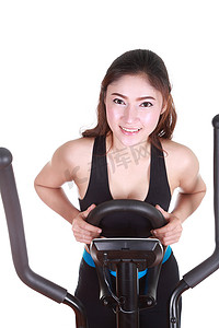 椭圆形不规则图形摄影照片_年轻女子用健身机锻炼
