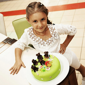 小女孩在生日时看着蛋糕