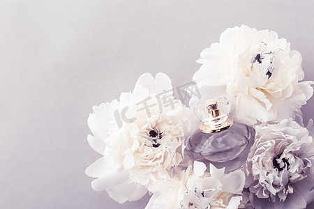 紫罗兰香水瓶作为牡丹花背景下的奢侈香水产品、香水广告和美容品牌