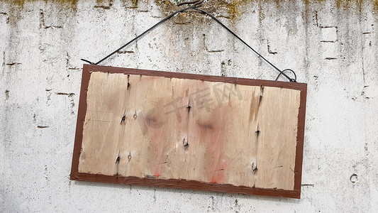 木牌挂摄影照片_灰色混凝土墙上挂着木牌。