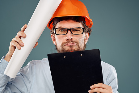 戴眼镜、带橙色头盔安全工作建设文件的男子
