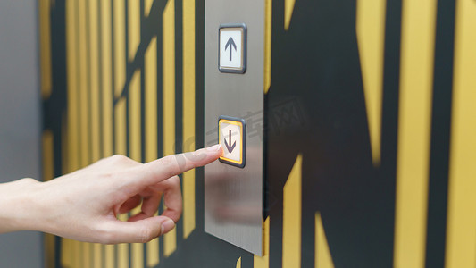 女人手指按下 th 里面电梯按钮的向下按钮