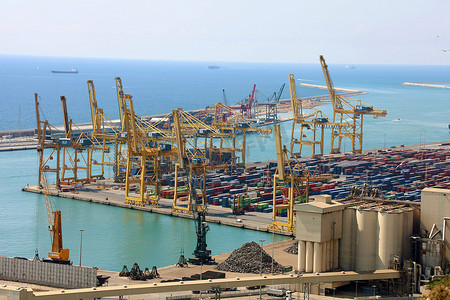西班牙巴塞罗那 — 2018年7月12日：巴塞罗那海运河港前装有集装箱和石煤的黄色高起重机