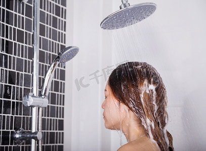 蓝色花洒矢量摄影照片_女人用洗发水在花洒淋浴中洗头和头发