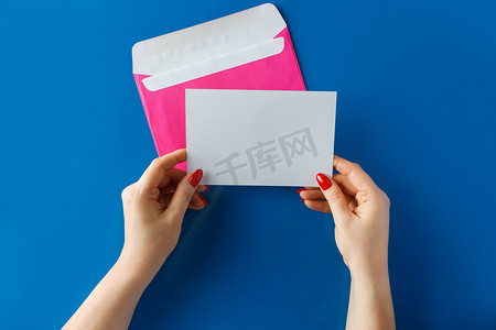 粉色信封，手中有一张空卡，背景为蓝色。