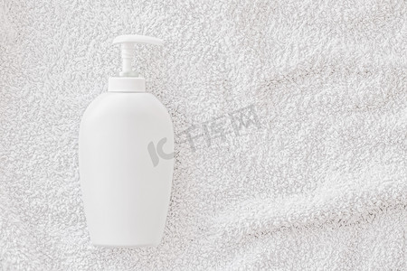 产品模型摄影照片_空白标签化妆品容器瓶作为白毛巾背景上的产品模型